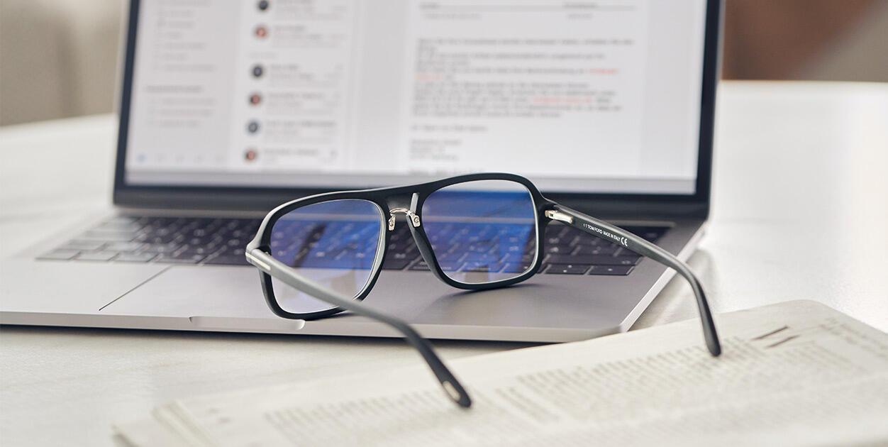 image of blue light blocking glasses resting by a laptop